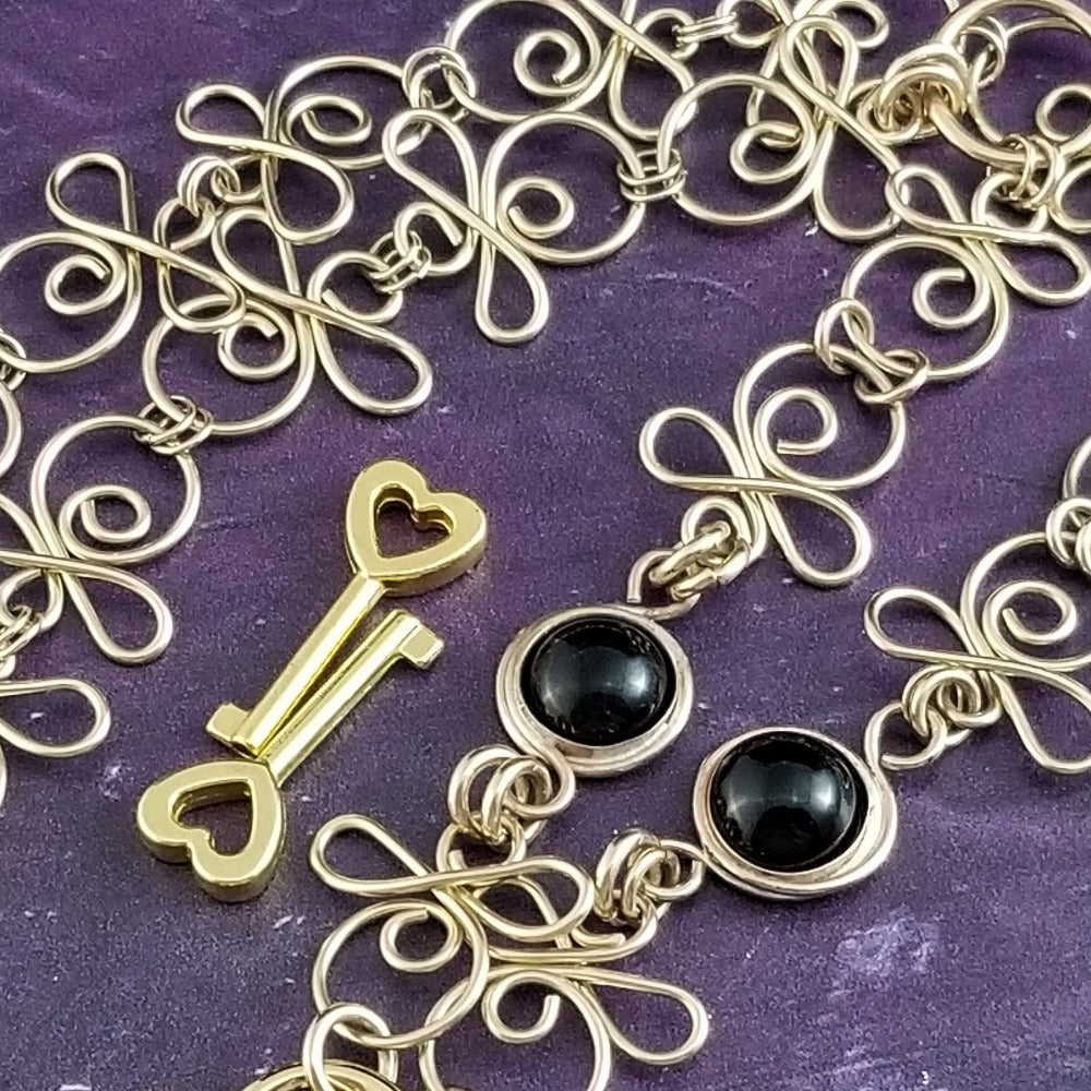 Made a bold statement of your Dominant / submissive lifestyle. The CELTIC PRIESTESS locking submissive collar features chain links inspired by Celtic knots, all created entirely by hand. Embellished with 2 natural Black Onyx gemstone cabochons. My Secret Studios 001
