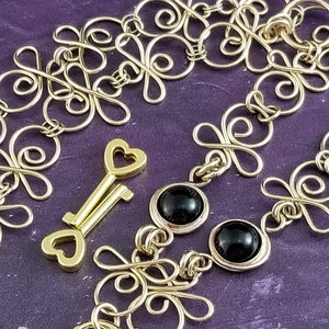 Made a bold statement of your Dominant / submissive lifestyle. The CELTIC PRIESTESS locking submissive collar features chain links inspired by Celtic knots, all created entirely by hand. Embellished with 2 natural Black Onyx gemstone cabochons. My Secret Studios 001