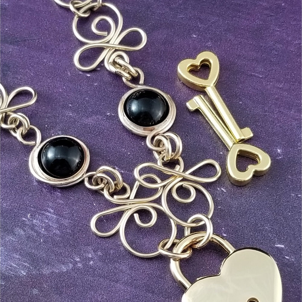 Made a bold statement of your Dominant / submissive lifestyle. The CELTIC PRIESTESS locking submissive collar features chain links inspired by Celtic knots, all created entirely by hand. Embellished with 2 natural Black Onyx gemstone cabochons. My Secret Studios 001
