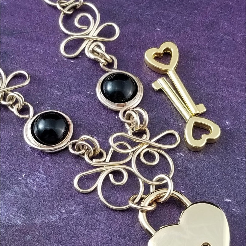 Made a bold statement of your Dominant / submissive lifestyle. The CELTIC PRIESTESS locking submissive collar features chain links inspired by Celtic knots, all created entirely by hand. Embellished with 2 natural Black Onyx gemstone cabochons. My Secret Studios 001