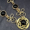 Features chain links inspired by Celtic knots, all created entirely by hand using only a few hand tools. The links are then tumbled with steel shot, creating strength and durability, as well as a silky smoothness.   The center medallion is a gold plated Celtic Triquetra Knot set with natural Black Onyx. My Secret Heart Studios.