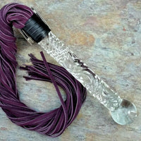 Get your kink on with this BDSM Flogger in Purple Leather and Glass. With a whip on one end and a glass dildo on the other, you’ll have the perfect balance between pleasure and pain! Can be Monogrammed / Engraved. By My Secret Heart Studios