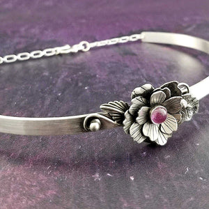 Adorn your sub or yourself with something unique. This BSDM locking submissive collar is pure luxury in sterling silver and features a hand cut and sculpted rose and gemstone. Can be worn locked or with traditional clasp for total discretion.