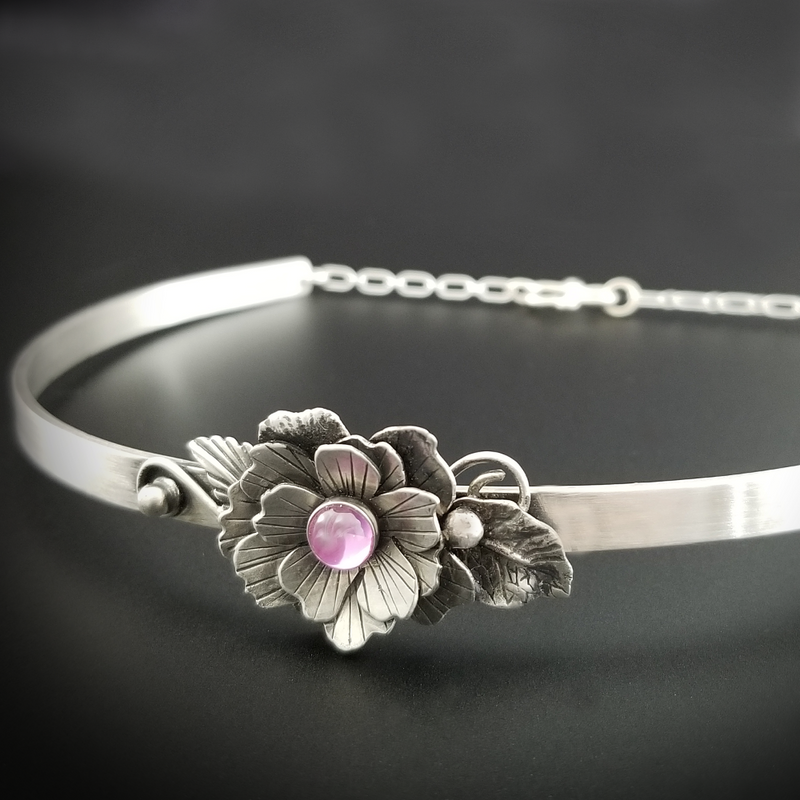 Adorn your sub or yourself with something unique. This BSDM locking submissive collar is pure luxury in sterling silver and features a hand cut and sculpted rose and gemstone. Can be worn locked or with traditional clasp for total discretion.