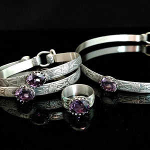 This Soft and Sweet artisan submissive collar is handcrafted in a floral pattern of sterling silver set with a 12 x 10mm simulated faceted amethyst gemstone.  By My Secret Heart Studios