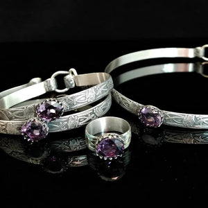 These artisan submissive BDSM handcuff bracelets are hand crafted in a classic floral pattern of sterling silver with faceted emerald gemstones, by My Secret Heart StudiosThese artisan submissive BDSM handcuff bracelets are hand crafted in a classic floral pattern of sterling silver with faceted Amethyst gemstones.