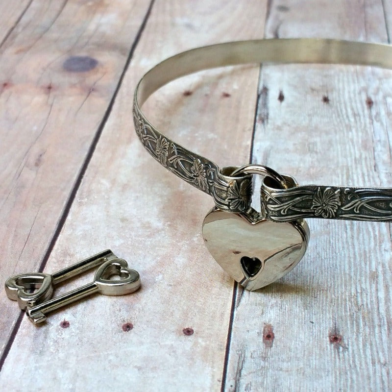 A MY SECRET HEART STUDIOS heart shaped locket with a key next to it.