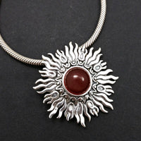 Dramatic Fire pendant with hand set with a  gemstone cabochon in your choice of black onyx, carnelian or moonstone. The pendant is sterling silver, the bail is silver plated. Can be worn as a pendant on a chain, or slide onto most all or our artisan collars.