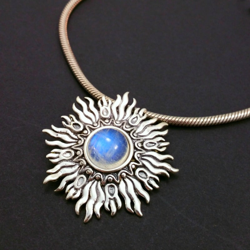 Dramatic Fire pendant with hand set with a  gemstone cabochon in your choice of black onyx, carnelian or moonstone. The pendant is sterling silver, the bail is silver plated. Can be worn as a pendant on a chain, or slide onto most all or our artisan collars.
