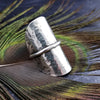 Minimalist style meets a bold design. Inspired to be a bold statement alone, yet will compliment any and all of your other jewelry. The top medallion is hand cut and hammered, then wrapped with a slim band of silver. It curves and hugs the top and sides of the finger for a all-day comfortable fit. 