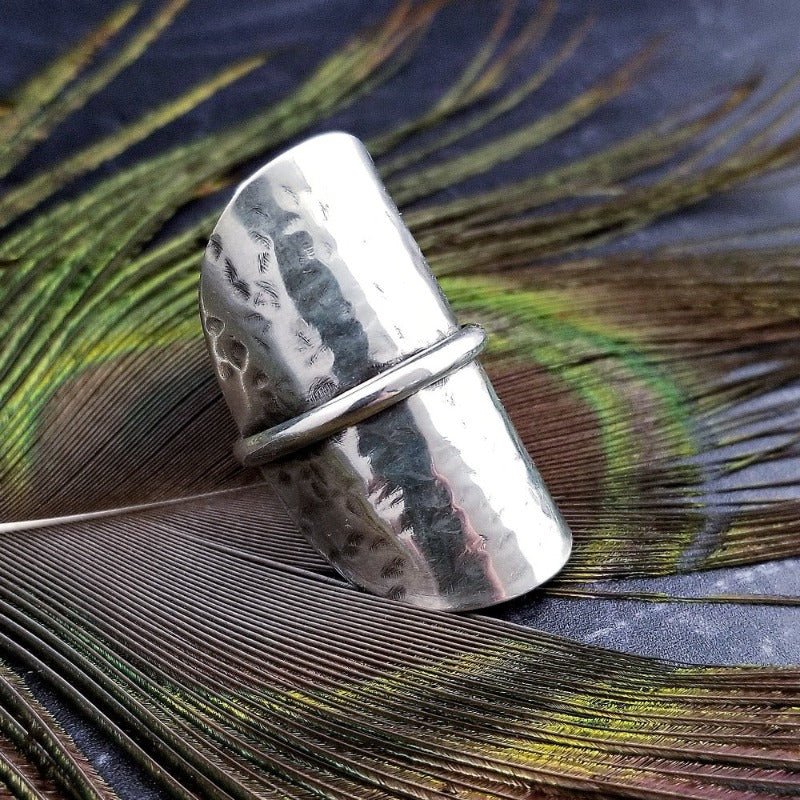 Minimalist style meets a bold design. Inspired to be a bold statement alone, yet will compliment any and all of your other jewelry. The top medallion is hand cut and hammered, then wrapped with a slim band of silver. It curves and hugs the top and sides of the finger for a all-day comfortable fit. 