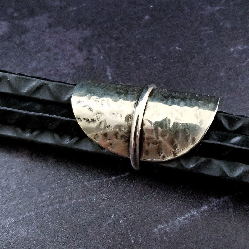 Minimalist style meets a bold design. Inspired to be a bold statement alone, yet will compliment any and all of your other jewelry. The top medallion is hand cut and hammered, then wrapped with a slim band of silver. It curves and hugs the top and sides of the finger for a all-day comfortable fit. 