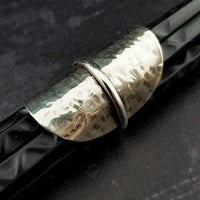 Minimalist style meets a bold design. Inspired to be a bold statement alone, yet will compliment any and all of your other jewelry. The top medallion is hand cut and hammered, then wrapped with a slim band of silver. It curves and hugs the top and sides of the finger for a all-day comfortable fit. 