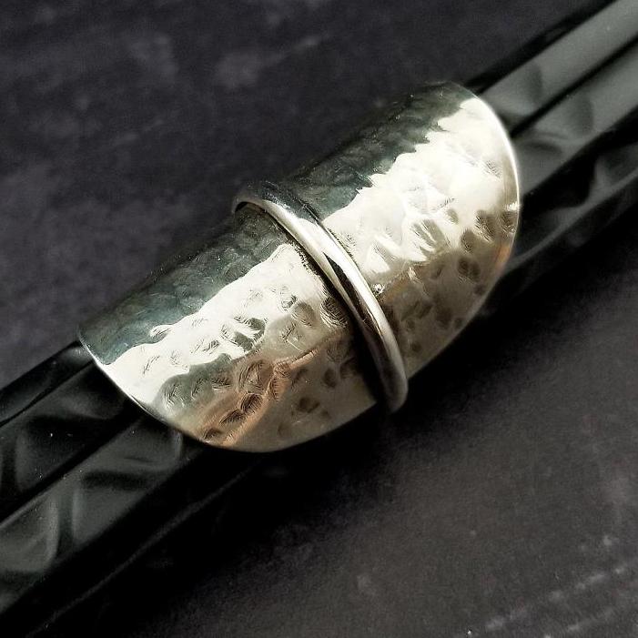Minimalist style meets a bold design. Inspired to be a bold statement alone, yet will compliment any and all of your other jewelry. The top medallion is hand cut and hammered, then wrapped with a slim band of silver. It curves and hugs the top and sides of the finger for a all-day comfortable fit. 