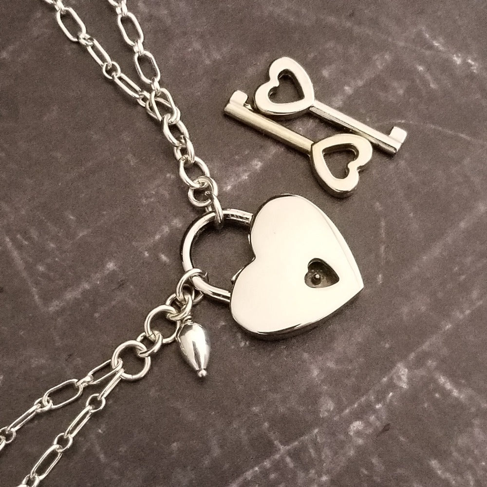 A beautiful symbol of your D/s dynamic, this contemporary V Style Locking BDSM submissive collar is hand crafted in mixed precious metals of sterling silver and gold. As strong and beautiful as the submissive’s heart, this high-quality artisan collar is made to last and will be the foundation of your private collection