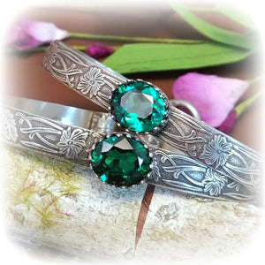 These artisan BDSM submissive handcuff bracelets are hand crafted in a classic floral pattern of sterling silver with faceted emerald gemstones.