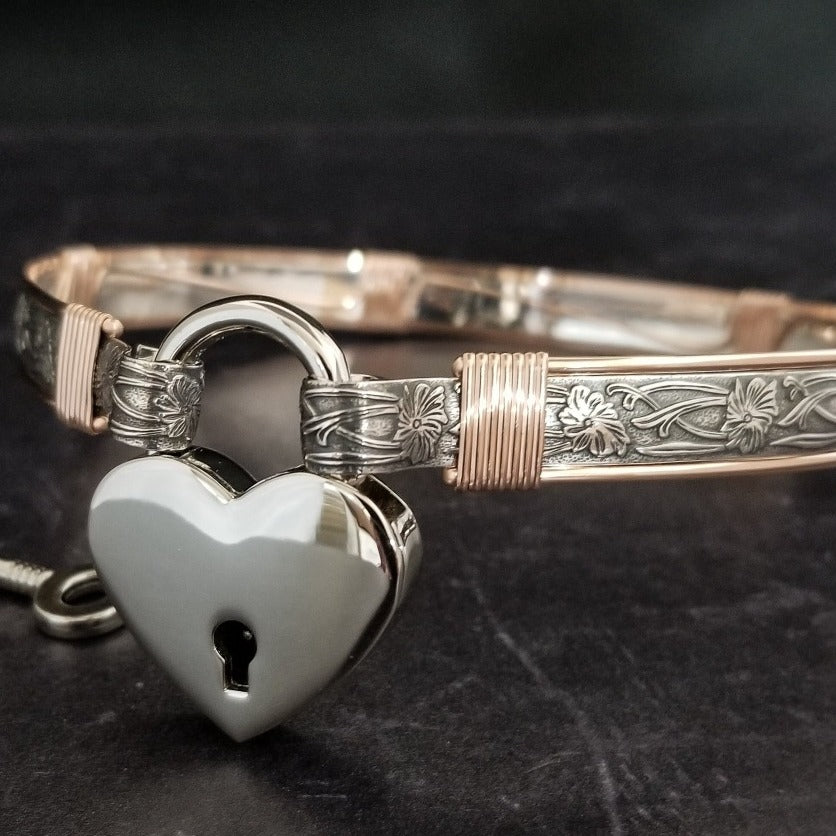 Show your ownership or submission with style and grace. Our best selling ‘SOFT and SWEET’ Locking BDSM submissive collar is now available in Sterling Silver with Rose Gold Accents. This artisan collar is hand crafted in a pretty feminine floral pattern that is the epitome of feminine grace. 