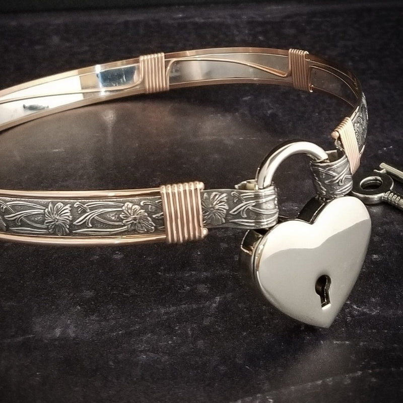 Show your ownership or submission with style and grace. Our best selling ‘SOFT and SWEET’ Locking BDSM submissive collar is now available in Sterling Silver with Rose Gold Accents. This artisan collar is hand crafted in a pretty feminine floral pattern that is the epitome of feminine grace. 