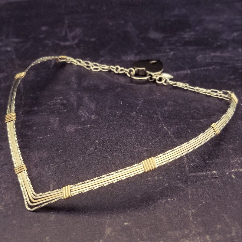A beautiful symbol of your D/s dynamic, this contemporary V Style Locking BDSM submissive collar is hand crafted in mixed precious metals of sterling silver and gold. As strong and beautiful as the submissive’s heart, this high-quality artisan collar is made to last and will be the foundation of your private collection