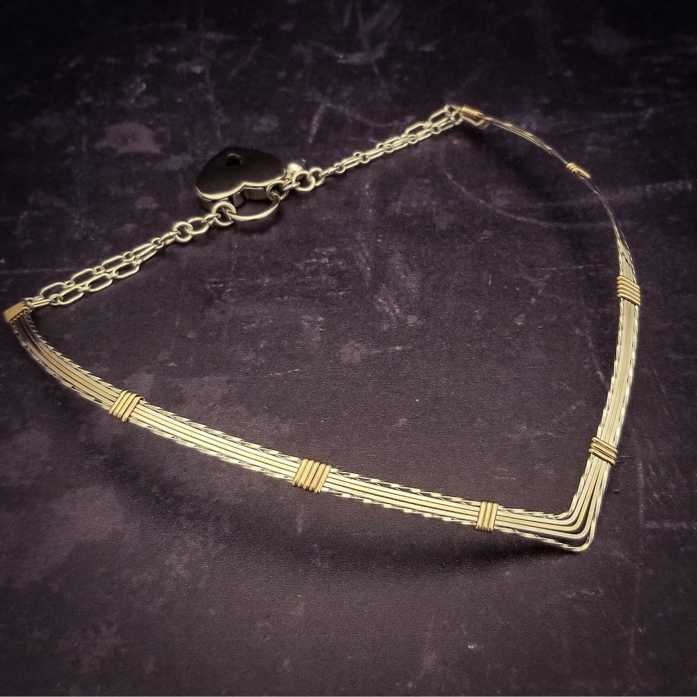 A beautiful symbol of your D/s dynamic, this contemporary V Style Locking BDSM submissive collar is hand crafted in mixed precious metals of sterling silver and gold. As strong and beautiful as the submissive’s heart, this high-quality artisan collar is made to last and will be the foundation of your private collection