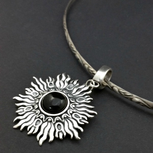 Dramatic Fire pendant with hand set with a  gemstone cabochon in your choice of black onyx, carnelian or moonstone. The pendant is sterling silver, the bail is silver plated. Can be worn as a pendant on a chain, or slide onto most all or our artisan collars.